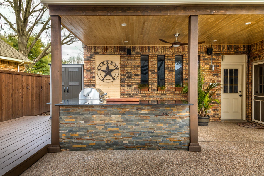 outdoor kitchen with a pergola and a stone countertop